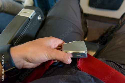 Fotografie Person adjusting waist belt and getting ready for plane to take off