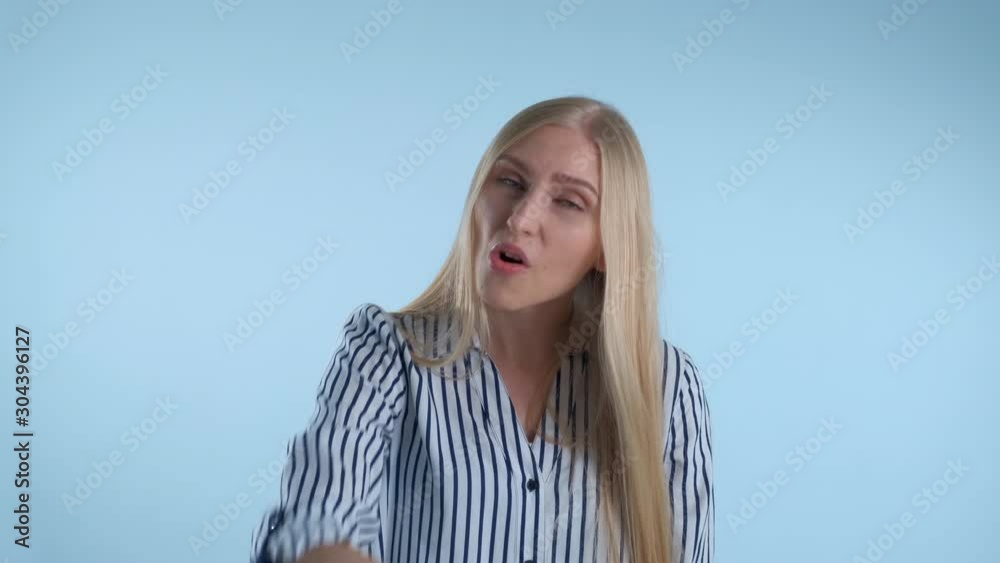 Young female showing gestures go away on blue background. She asking somebody to leave her. Young female showing gestures go away on blue background. She asking somebody to leave her.