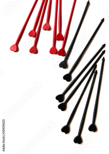 Black and red sticks for canapes whith heart on a white isolated background. Decorative chopsticks.