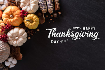Top view of  Autumn maple leaves with Pumpkin and red berries on black wooden background. Thanksgiving day concept.