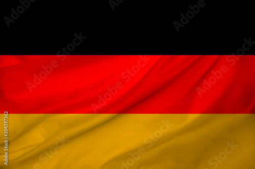 beautiful photo of the colored national flag of the modern state of Germany on textured fabric  concept of tourism  emigration  economics and politics  closeup