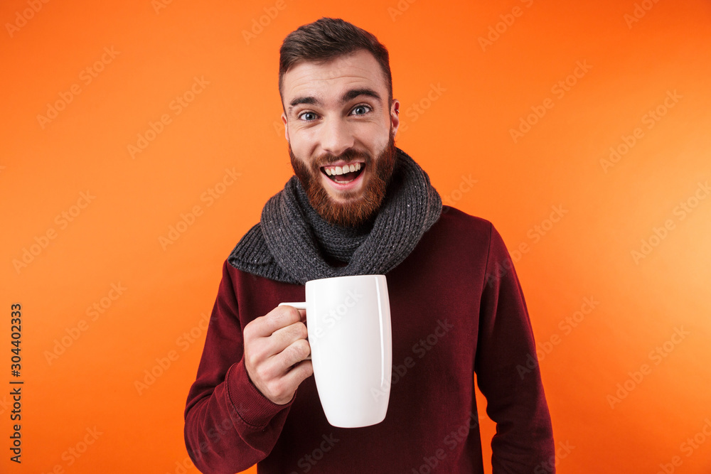Happy man holding cup of hot tea wearing scarf. Happy man holding cup of hot tea wearing scarf.