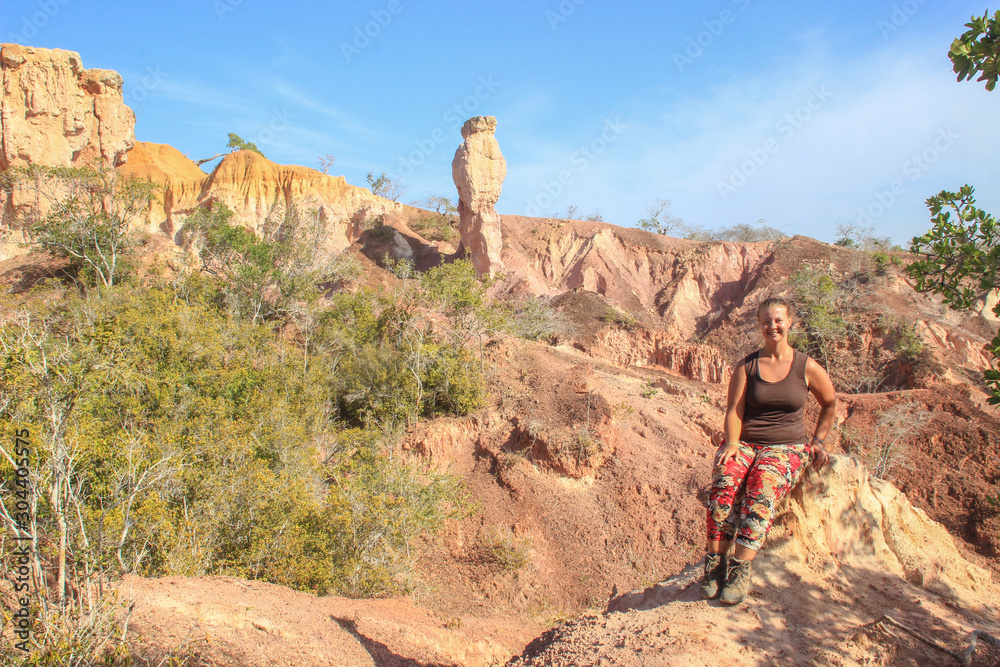 The famous attraction in Kenya is the gorge of Hell's Kitchen - stones and rocks with colorful sand near Marafa, Malindi. East Africa Erosion of sand cliffs. Caucasian girl tourist. The famous attraction in Kenya is the gorge of Hell's Kitchen - stones and rocks with colorful sand near Marafa, Malindi. East Africa Erosion of sand cliffs. Caucasian girl tourist.