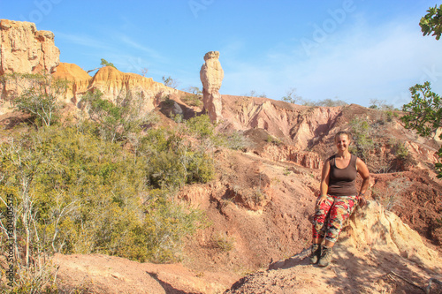 The famous attraction in Kenya is the gorge of Hell's Kitchen - stones and rocks with colorful sand near Marafa, Malindi. East Africa Erosion of sand cliffs. Caucasian girl tourist.