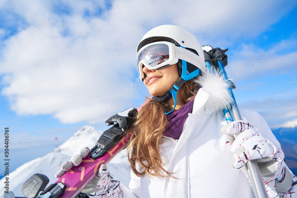 Portrait of beautiful woman with ski and ski suit in winter mountain. - obrazy, fototapety, plakaty 