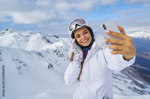 Girl Makes A Selfie In Ski Clothing On Snow Mountain.