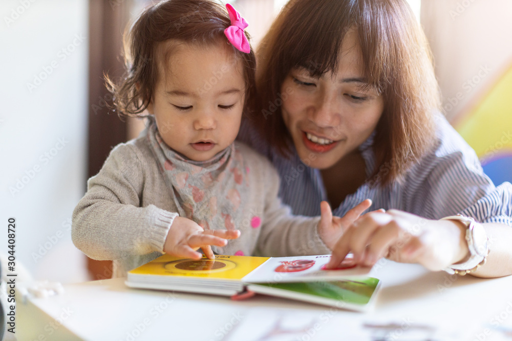 Mother and daughter reading a book together Mother and daughter reading a book together