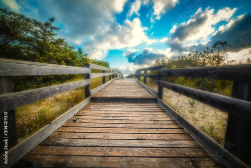 Wooden boardwalk by the sea at sunset © Gabriele Maltinti