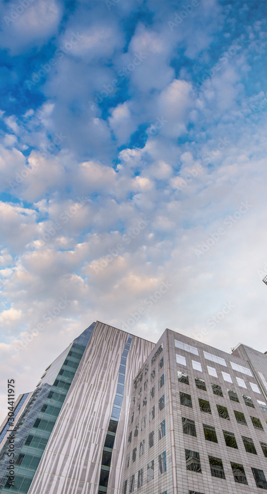 Beautiful modern skyscrapers at sunset, upward view from the street. Business concept