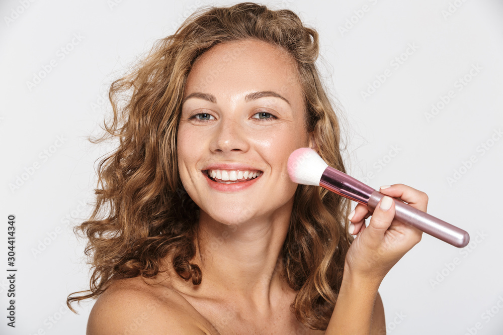 Image of beautiful half-naked woman smiling and using makeup brush