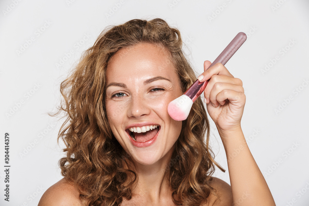 Image of funny half-naked woman smiling and using makeup brush - obrazy, fototapety, plakaty 