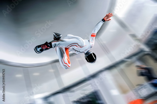 Indoor. Man fly in wind tunnel. Indoor skydiving. New fly sport.
