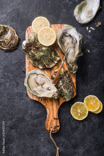 Fresh open Oysters. Healthy sea food. Dinner in restaurant. Gourmet food. Dark background. Top view Healthy sea food.