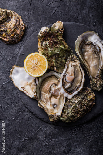 Fresh open Oysters. Healthy sea food. Dinner in restaurant. Gourmet food. Dark background. Top view