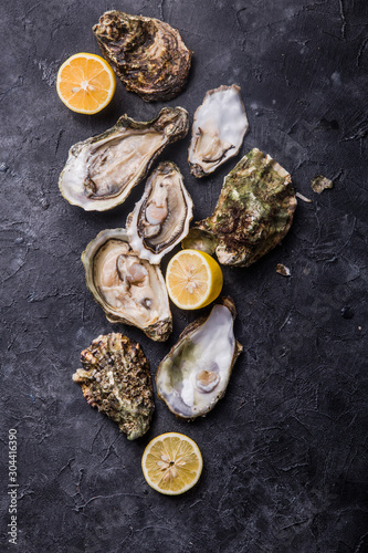 Fresh open Oysters. Healthy sea food. Dinner in restaurant. Gourmet food. Dark background. Top view © Maria