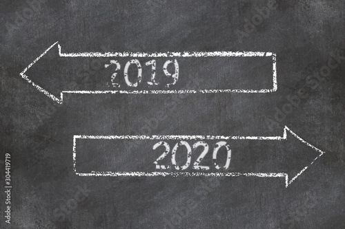 Two direction signs with arrows and numbers 2019 and 2020 on chalkboard background.