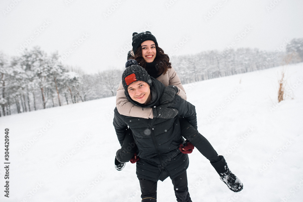 Couple in love walking in the snowy woods Couple in love walking in the snowy woods