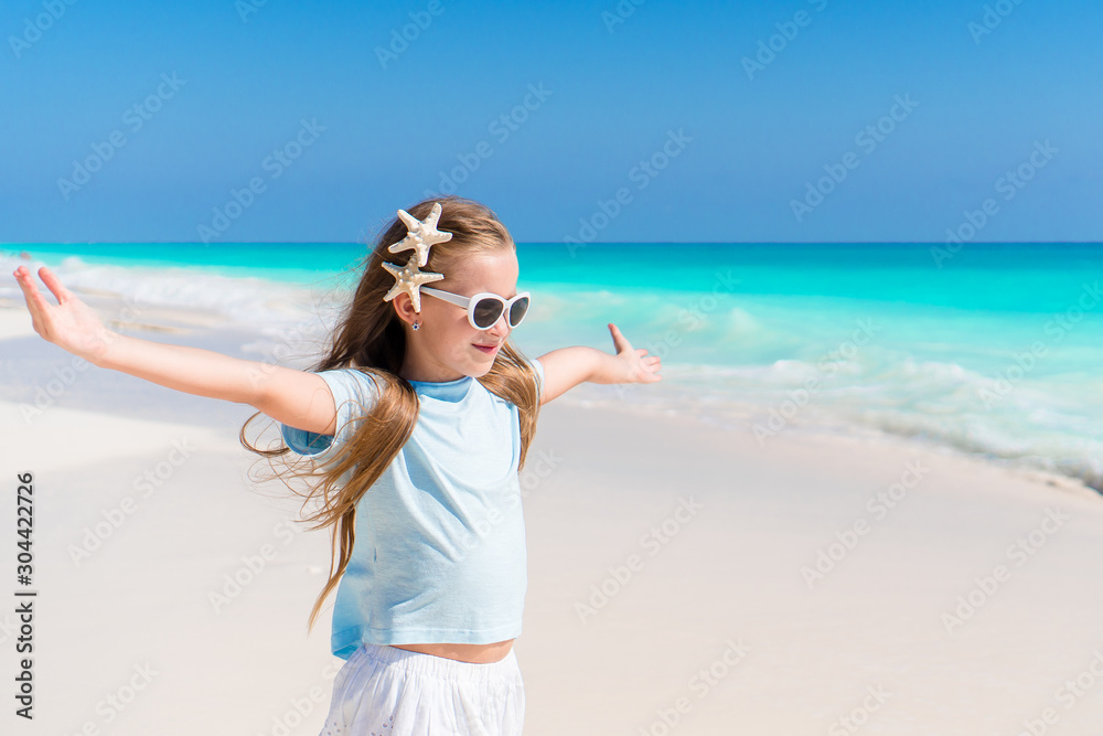 Beautiful little girl in dress at beach having fun. Funny girl enjoy summer vacation.