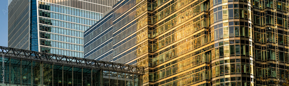 Modern city building architecture with glass fronts on a clear day at sunset in London, England panoramic