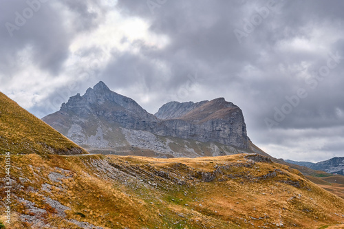 Rocky mountains covered with autumn meadow against the background of a stormy sky