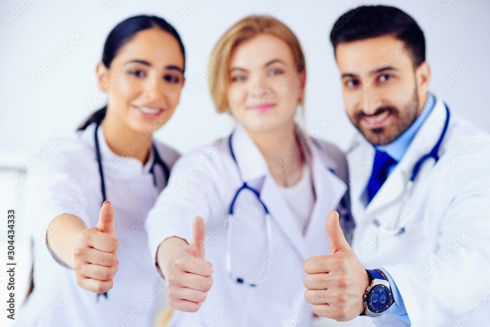 Arab and european doctors shows thumb up. Healthcare concept Arab and european doctors shows thumb up. Healthcare concept