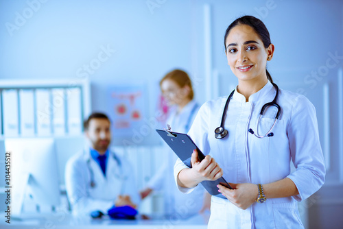 Arabian Doctor standing in Front of her team in the hospital