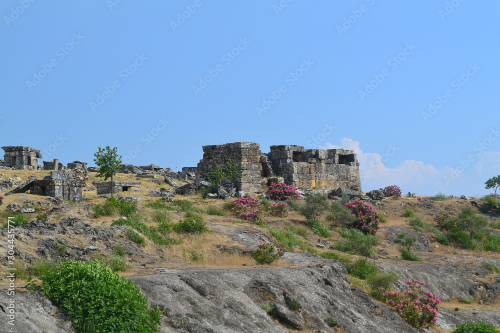 Old Hierapolis ruins, amphitheatre and touristic locations captured with hill background, in daytime.