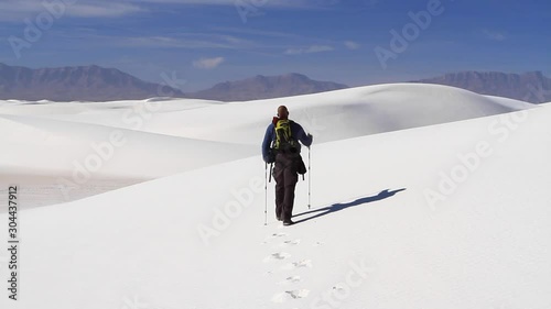 A lone hiker enters the vast expanse of White Sands National Monument. photo