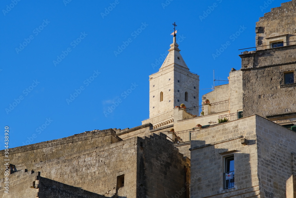 Houses and bell tower in the city of Matera in Italy. The tuff blocks are the material used for the construction of the houses.