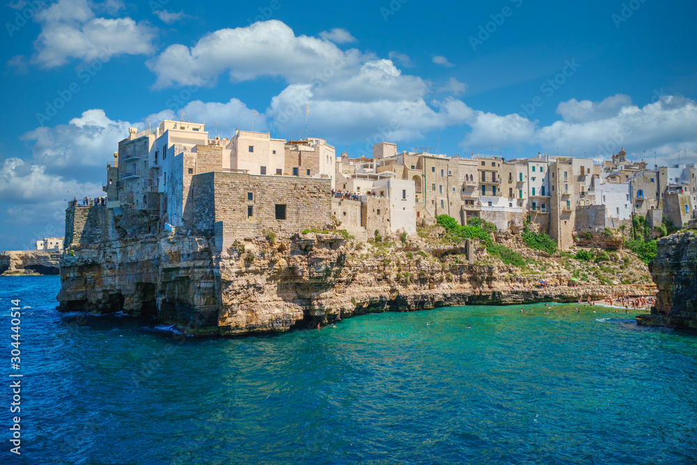 Houses on a rocky seashore in the popular tourist town of Polignano a Mare, sunny summer day