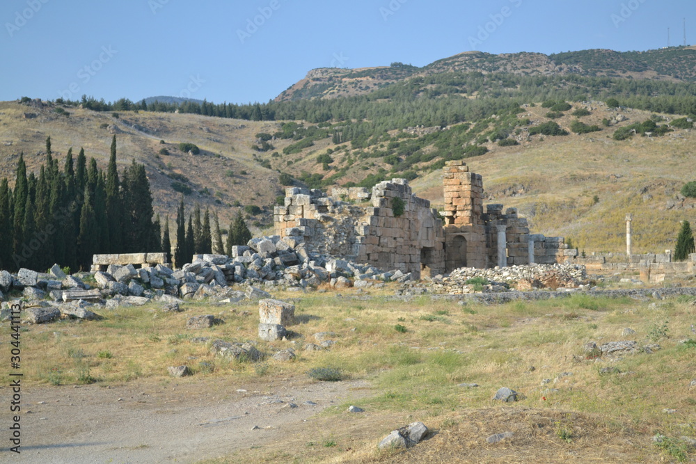 Obraz premium Old Hierapolis ruins, amphitheatre and touristic locations captured with hill background, in daytime.