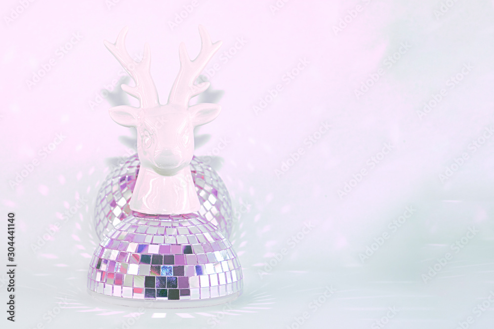 A sculpture of a deer head standing on a disco ball on a pink mint background. Concept abstraction, party. A sculpture of a deer head standing on a disco ball on a pink mint background. Concept abstraction, party.