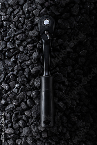 Professional reinforced black matt hex wrench placed on a stony background. View from the top. photo