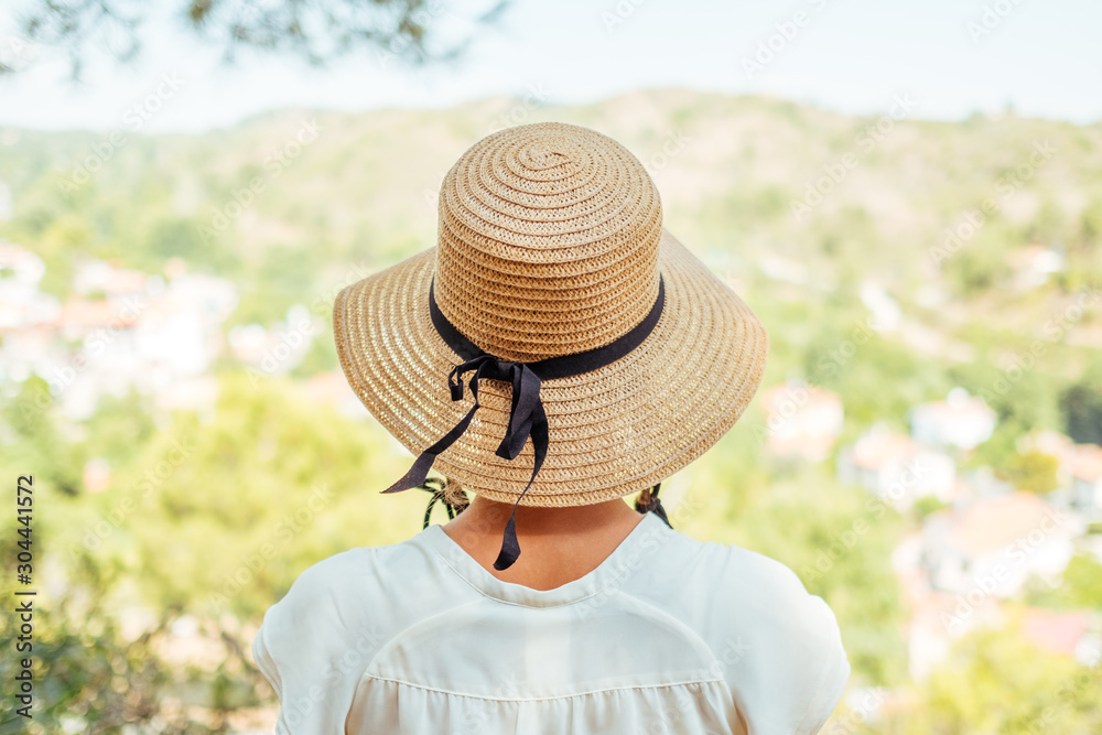 Beautiful woman wearing straw hat looking valley view