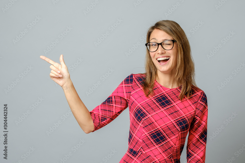 Pretty cheerful woman gesturing with fingers and hand and showing away Pretty cheerful woman gesturing with fingers and hand and showing away