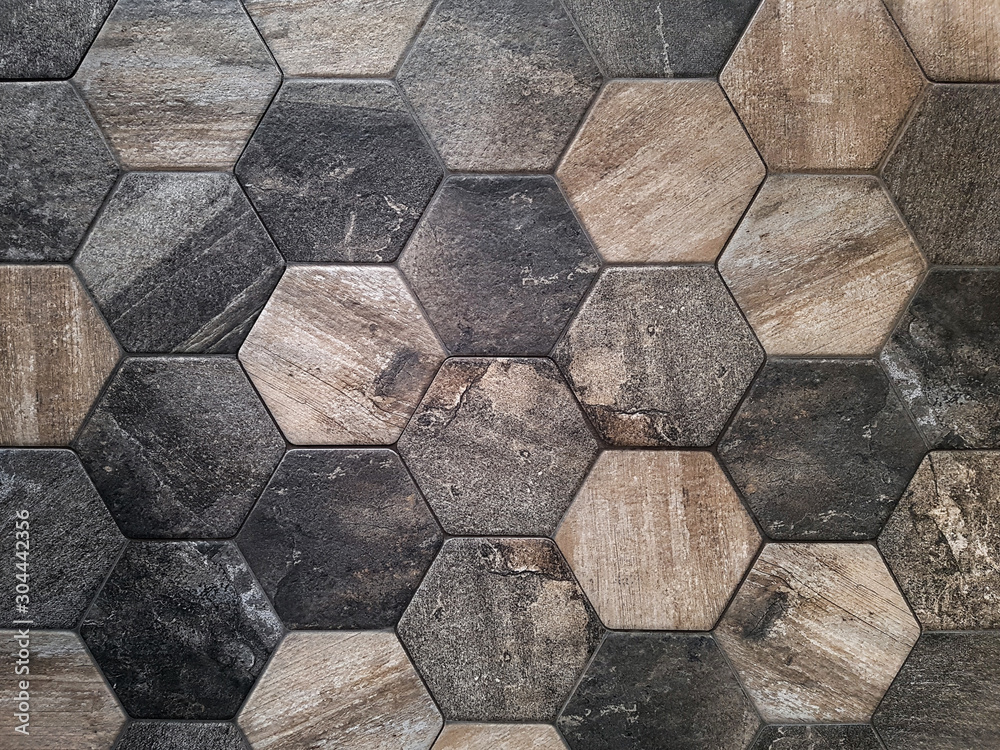 The texture of the ceramic tiles in the form of a hexagon made of brown natural stone. Concept texture, background. The texture of the ceramic tiles in the form of a hexagon made of brown natural stone. Concept texture, background.