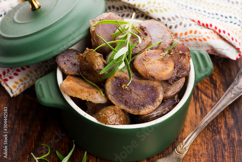 Fired violet potato slices with herbs, close view photo