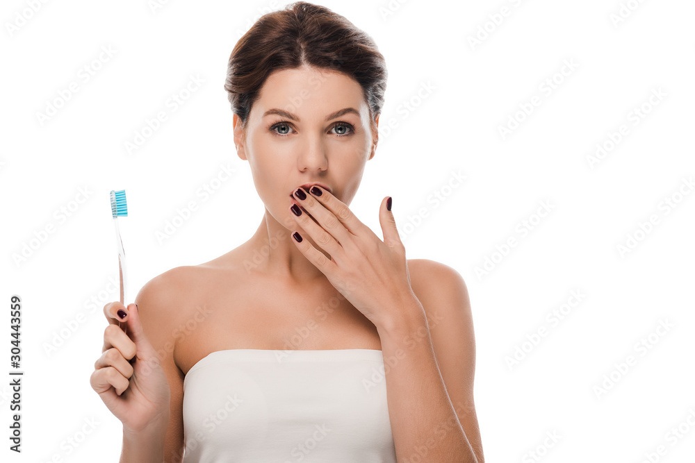 shocked woman covering mouth and holding toothbrush isolated on white shocked woman covering mouth and holding toothbrush isolated on white