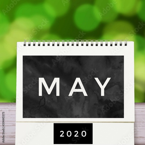 White blank paper desk spiral May calendar on wood with green abstract background. Calender of 2020 and empty month or Date to enter text and numbers.