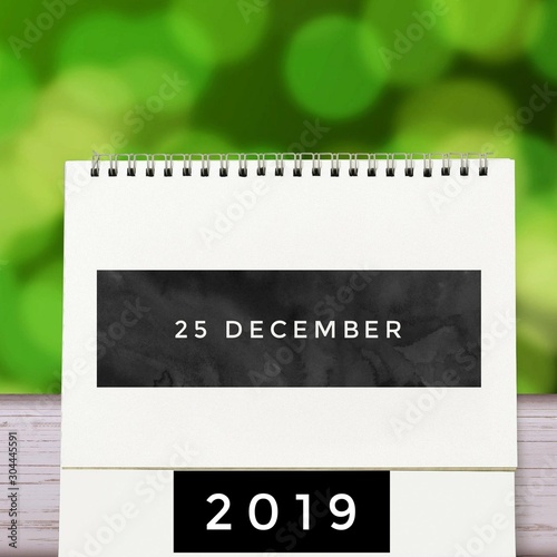 December 25 2019 calendar Christmas day. old wood table, green nature background, 25 december text, countdown to holiday season, merry christmas, happy new year 2019 concept.