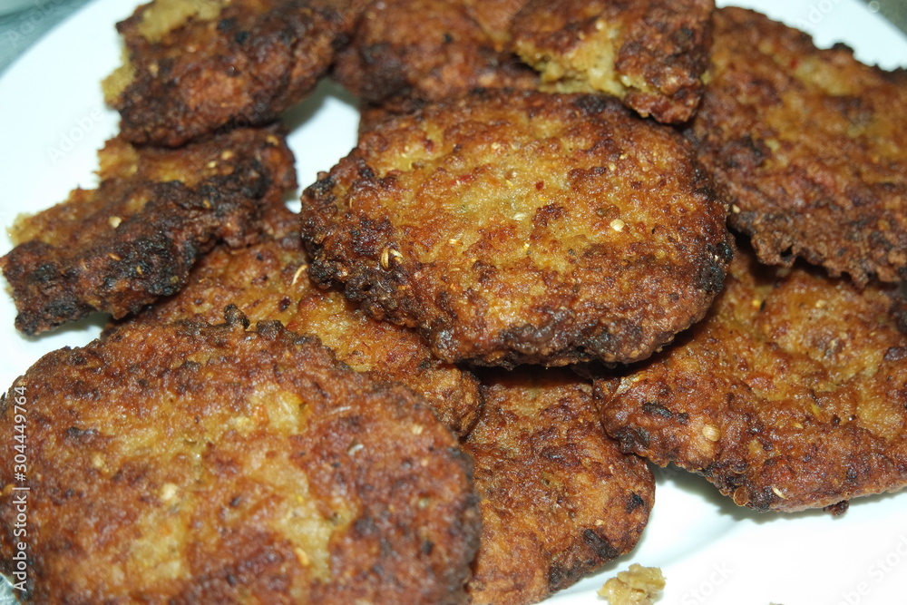 Delicious spicy fried round kebab served in white ceramic plate Delicious spicy fried round kebab served in white ceramic plate