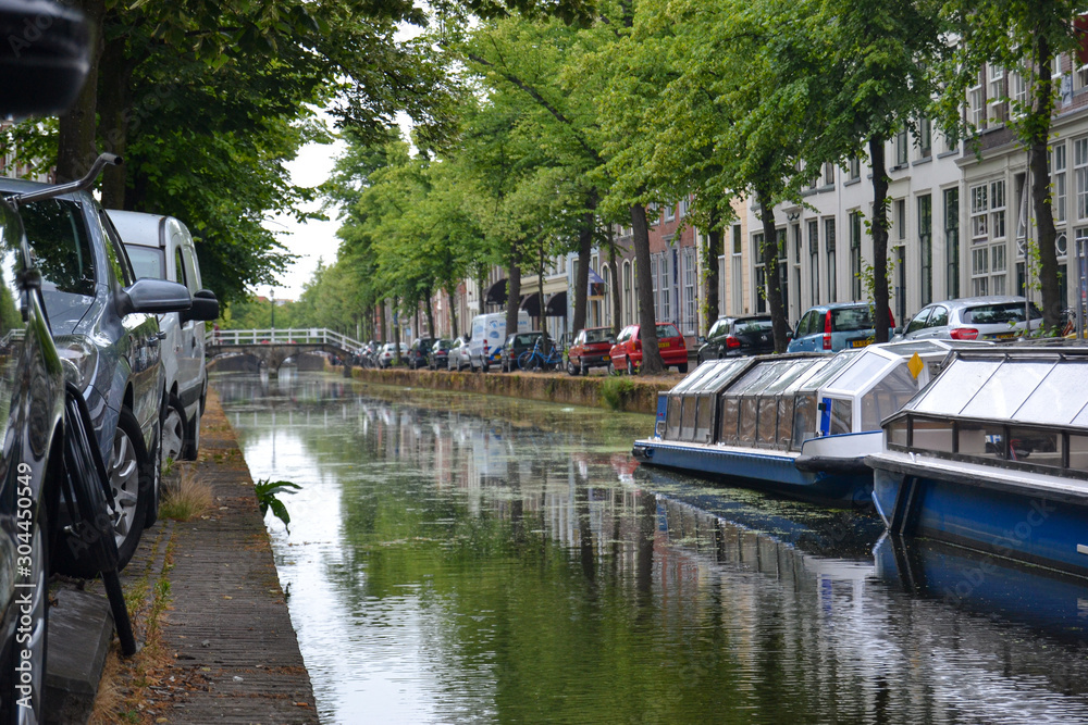 Naklejka premium detail of a typical holland boats on the canals and cars parked on a cloudy day