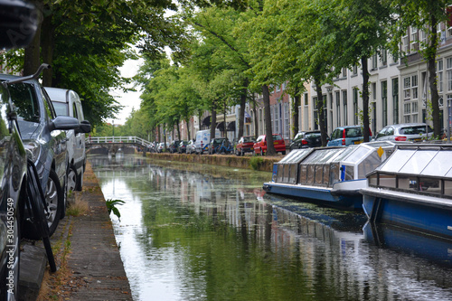 detail of a typical holland boats on the canals and cars parked on a cloudy day