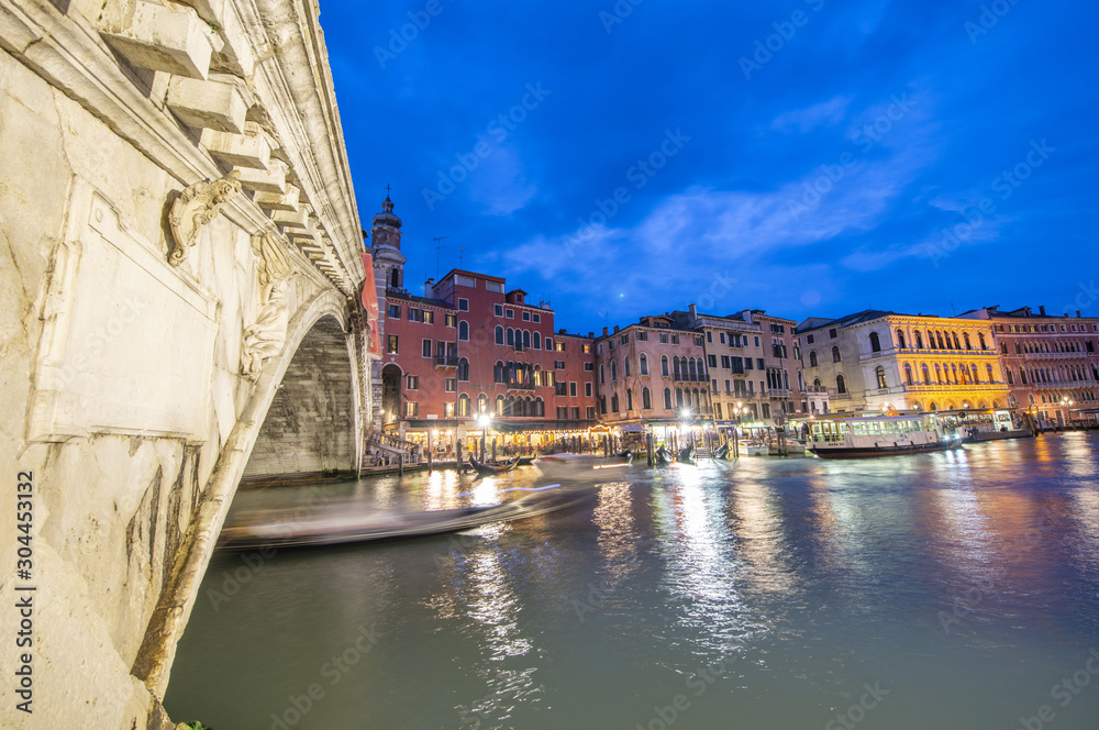 VENICE, ITALY - APRIL 2014: Rialto Bridge at night with city restaurants along grand canal