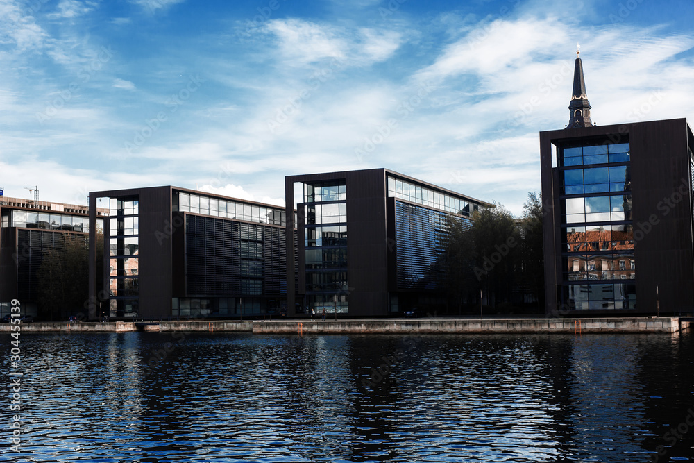 Naklejka premium BUSiNESS CENTER IN COPENHAGEN, DENMARK. Row of modern buildings near the river.