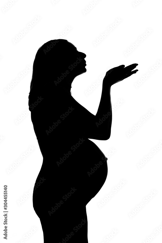 silhouette of a pregnant woman on a white background. The mother-to-be held her hands out in front of her. The concept of a healthy lifestyle, IVF, expression of emotions, gestures. Copy space