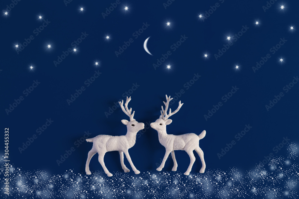 White Christmas reindeer on blue background with snow, stars and moon. Xmas greeting card with wishes. Flat lay. White Christmas reindeer on blue background with snow, stars and moon. Xmas greeting card with wishes. Flat lay.