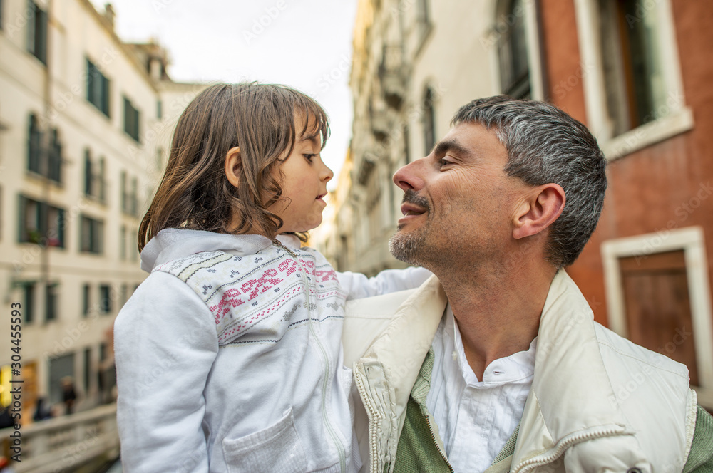Naklejka premium Father with little daughter looking each other with love in Venice, Italy