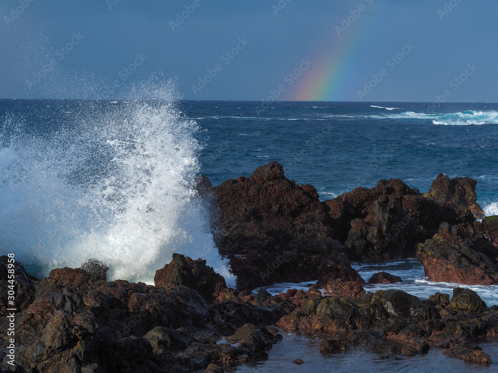 Atlantic waves crashing into volcanic rocks on the shore at Puerto de la Cruz, Tenerife, Canary Islands