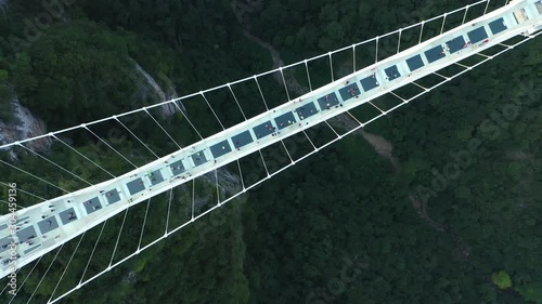 Overhead aerial view of tourists on  skywalk, crossing glass suspension bridge in Zhangjiajie, China photo